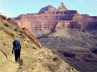 A HIKER ON THE S. KAIBAB TRAIL ABOUT HALF-WAY TO PHANTOM RANCH. ZOROASTER AND BRAHMA TEMPLES BEYOND. GRAND CANYON N. P. NPS PHOTO.